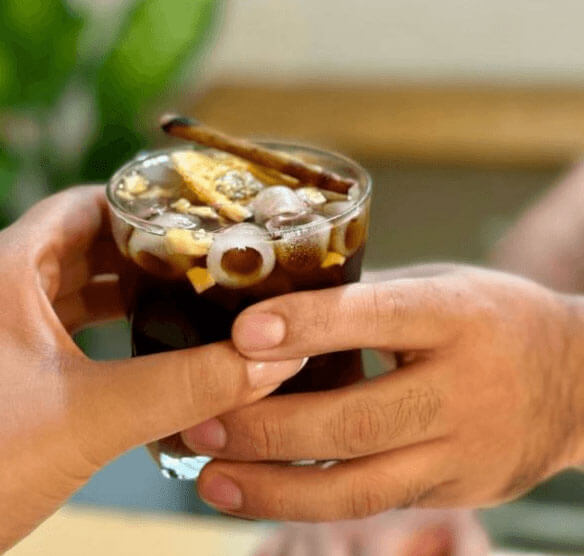 Hands holding an iced cold brew at SLOW